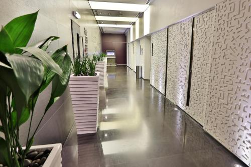 an office hallway with plants and a long corridor at The Act Hotel Sharjah in Sharjah