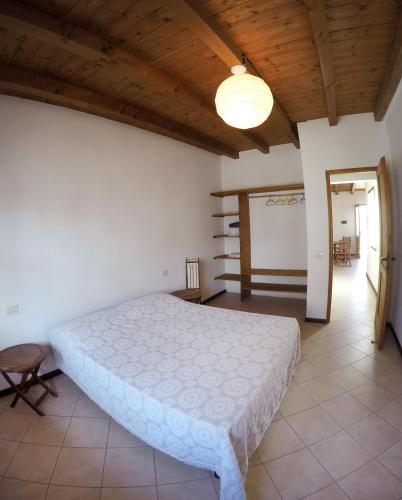 a bedroom with a white bed and a wooden ceiling at Ca' Greta - Big apartment close Estoril beach in Sal Rei