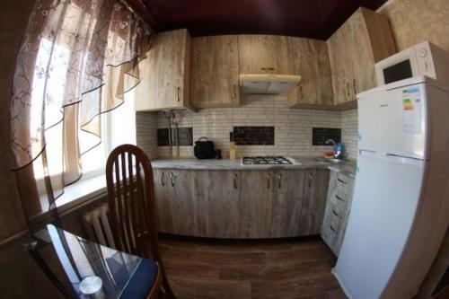 een keuken met houten kasten en een witte koelkast bij Карла Маркса in Kropyvnytsky