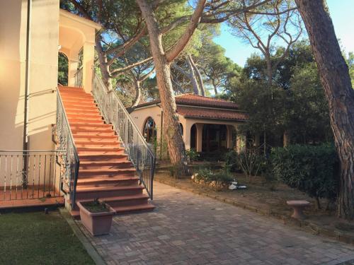 a house with a staircase in front of a house at Hotel Boschetto in Follonica