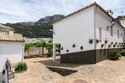 a white building with potted plants on the side at Villa Turística de Cazorla in Cazorla
