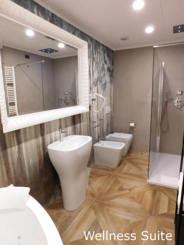 a bathroom with two toilets and a walk in shower at Best Western Plus Royal Superga Hotel in Cuneo