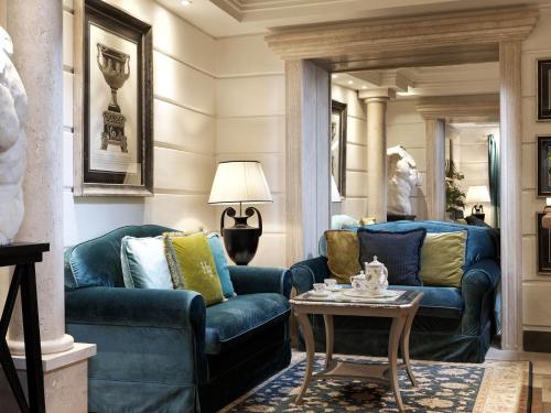 a living room with a blue couch and a table at Hotel Barocco in Rome
