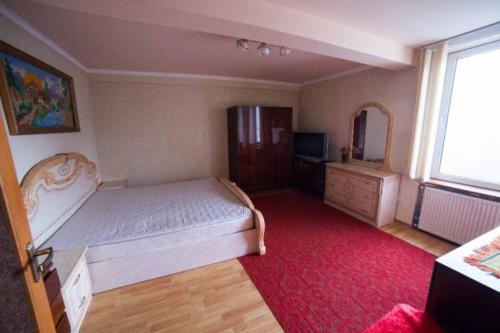 Un dormitorio con una cama grande y una alfombra roja en Domashnya Saduba, en Mukácheve