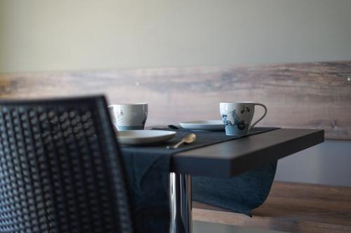 een zwarte tafel met twee kopjes en borden erop bij Marylinda in Desenzano del Garda
