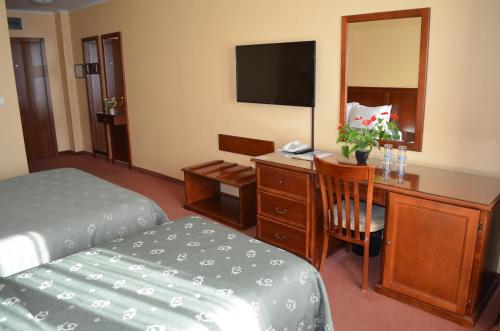 a hotel room with a bed, desk and television at Hotel Bankya Palace in Bankya