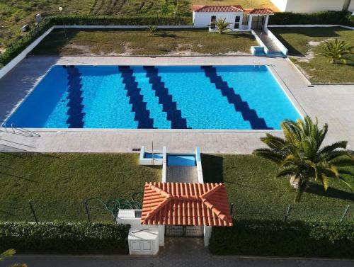 
a blue and white swimming pool with a blue sky at Apartamento Varandas do Sol Nascente in Porches
