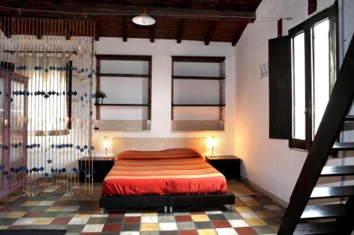 a bedroom with a red bed in a room with windows at Solsicily in Catania