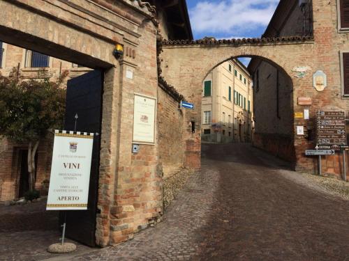 an alley in an old building with a sign on it at Appartamento Riva in Neive