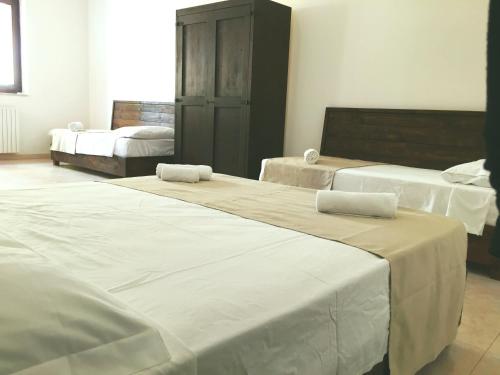 ガリポリにあるCasa Vacanza Mare Bluの白いシーツが備わるベッド3台が備わる部屋