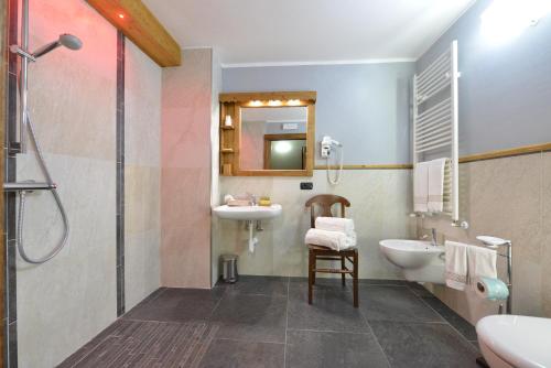 łazienka z umywalką, toaletą i prysznicem w obiekcie Mollino Rooms w mieście Breuil-Cervinia