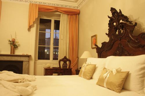 a bedroom with a bed and a fireplace and a window at Casa Manuel Espregueira e Oliveira in Viana do Castelo