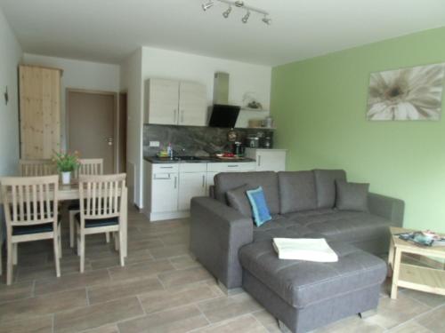 a living room with a couch and a table and a kitchen at FeWo am Bogen-Biwak in Groß Wasserburg