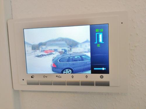 a television attached to a wall with a car on it at FeWo WELL in Gladenbach