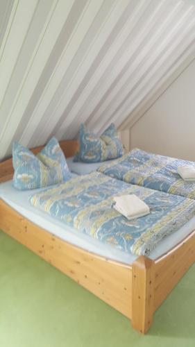 a wooden bed with blue sheets and pillows on it at Kapitänskoje in Breege