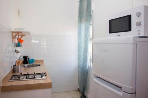 a kitchen with a white refrigerator and a sink at Apartamentos Calypso in Punta Umbría