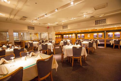 a dining room with white tables and chairs at Somerset Inn Troy in Troy