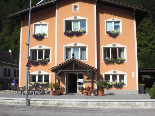 een groot oranje gebouw met bloembakken op de ramen bij Pension Kirchsteiger in Hohenberg