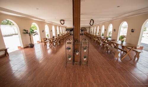a large room with tables and benches and windows at Pousada e Restaurante Manaím in Passa e Fica