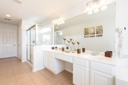 a white bathroom with a sink and a mirror at Beechfield Villa 7829 in Orlando