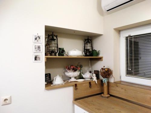 a shelf in a room with vases and a window at ROYAL apartment in Gabrovo