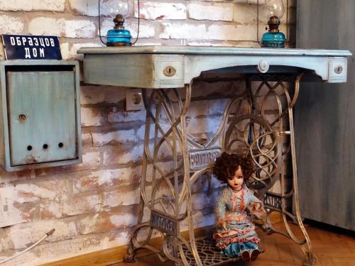 a doll sitting under a table in a room at ROYAL apartment in Gabrovo