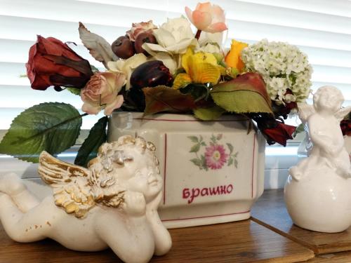 a vase with an angel and flowers on a table at ROYAL apartment in Gabrovo