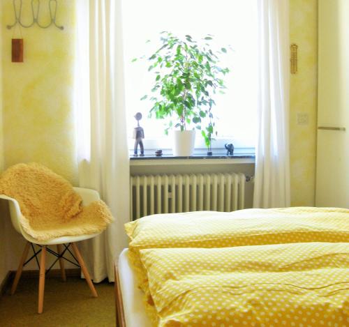 ein Schlafzimmer mit einem Bett, einem Stuhl und einem Fenster in der Unterkunft Gästezimmer in Rotenburg in Rotenburg an der Wümme