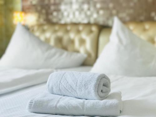 a stack of towels sitting on top of a bed at Hotel Vogelweiderhof in Salzburg