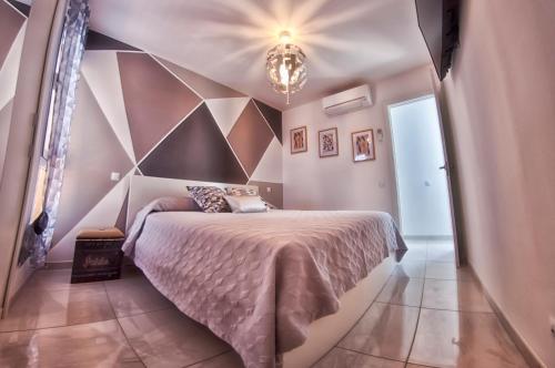 a bedroom with a bed with a geometric wall at Charming House in Maspalomas