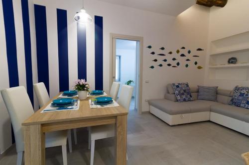 a dining room with a table and a couch at Kallion house in Vietri sul Mare