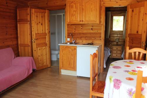 a kitchen with wooden cabinets and a table in a room at Hotel y Bungalows Balcón de Competa in Cómpeta