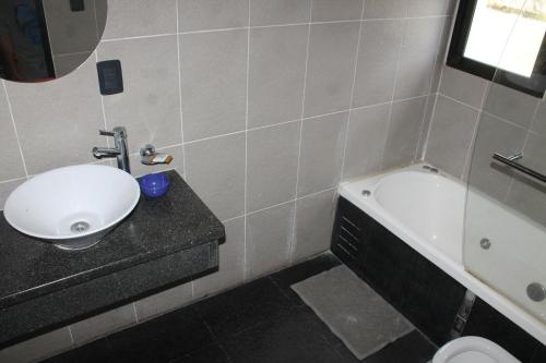 a bathroom with a sink and a bath tub at Cabañas Refugio Uritorco in Capilla del Monte