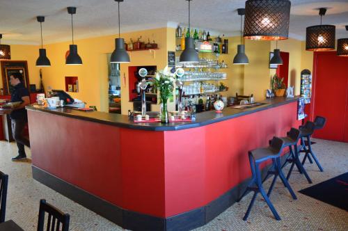een kleurrijke bar in een restaurant met stoelen bij Hôtel La Barguelonne in Montcuq