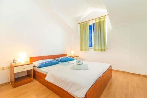 Schlafzimmer mit einem Bett und einem Fenster in der Unterkunft Apartmani Jerkin Vodice in Vodice