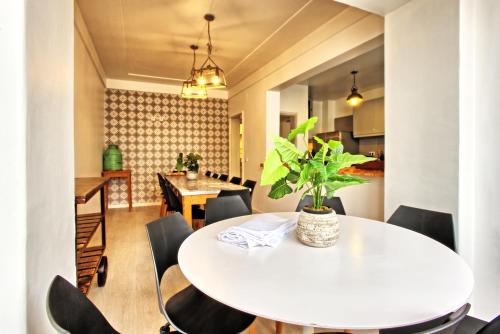 a dining room and kitchen with a white table and chairs at São Pedro 30 Guests Apartment in Lisbon