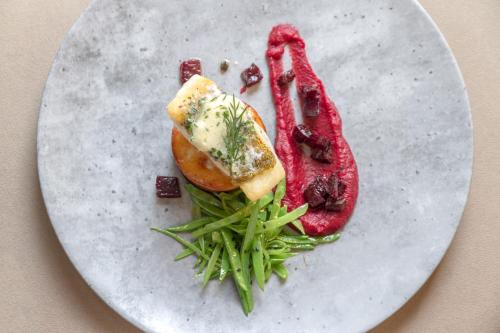 a plate of food with meat and green beans at Boutique Hotel U Solné brány in České Budějovice