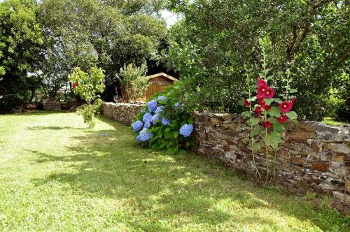 a garden with a stone wall and colorful flowers at Maison de Pêcheurs in Sarzeau
