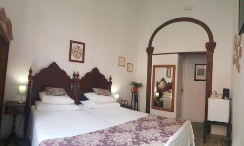 a bedroom with a large bed with white sheets at Los Canaritos in Las Palmas de Gran Canaria