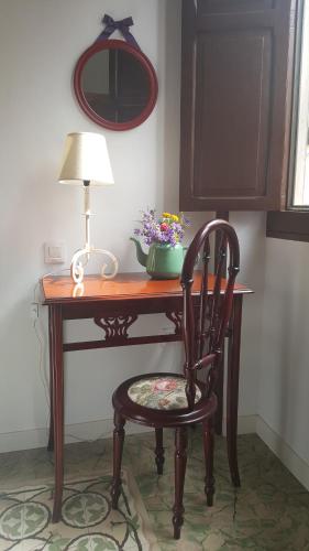 a desk with a chair and a lamp and flowers at Los Canaritos in Las Palmas de Gran Canaria