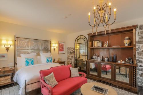 a bedroom with a bed and a red couch at Banyan Tree Puebla in Puebla