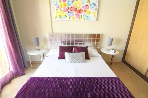 Un dormitorio con una cama grande con sábanas y almohadas púrpuras. en Anju Villas Bravo Apartments Cotillo, en Cotillo