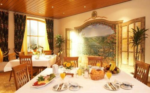 ein Esszimmer mit einem Tisch mit Essen drauf in der Unterkunft Hotel Alter Posthof in Spay