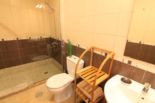 y baño con aseo, lavabo y ducha. en Anju Villas Bravo Apartments Cotillo, en Cotillo