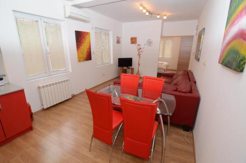 a living room with a table and red chairs at Maritimo Apartments in Kotor