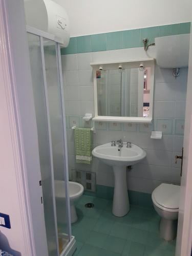 a bathroom with a sink and a toilet and a mirror at Casa Vittoria in Gaeta