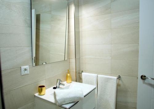 La salle de bains est pourvue d'un lavabo, d'un miroir et de serviettes. dans l'établissement Luxury Dreams Sevilla, à Séville