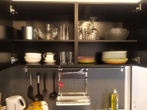una cocina con una estantería con platos y utensilios en GreatStay Saarbrücken, en Saarbrücken