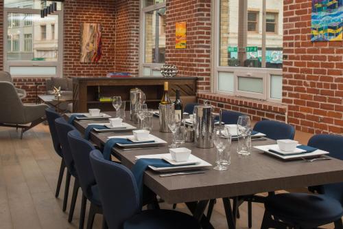 a long table in a restaurant with chairs and wine glasses at The Mark Spencer Hotel in Portland