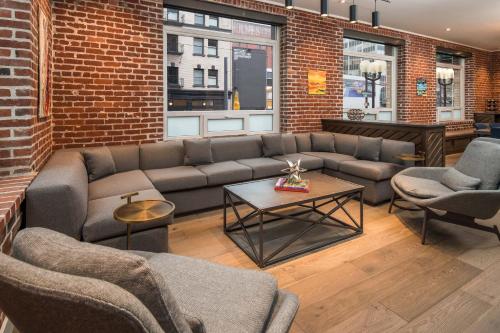 a living room with couches and a brick wall at The Mark Spencer Hotel in Portland